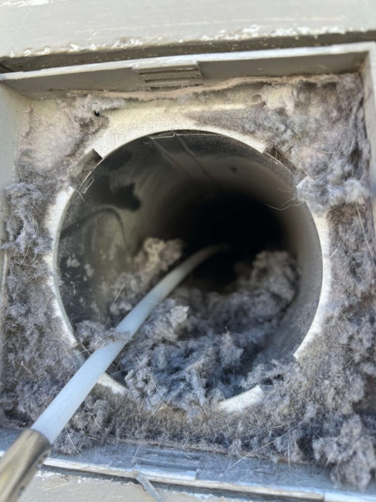 A clogged dryer vent full of lint and pet hair