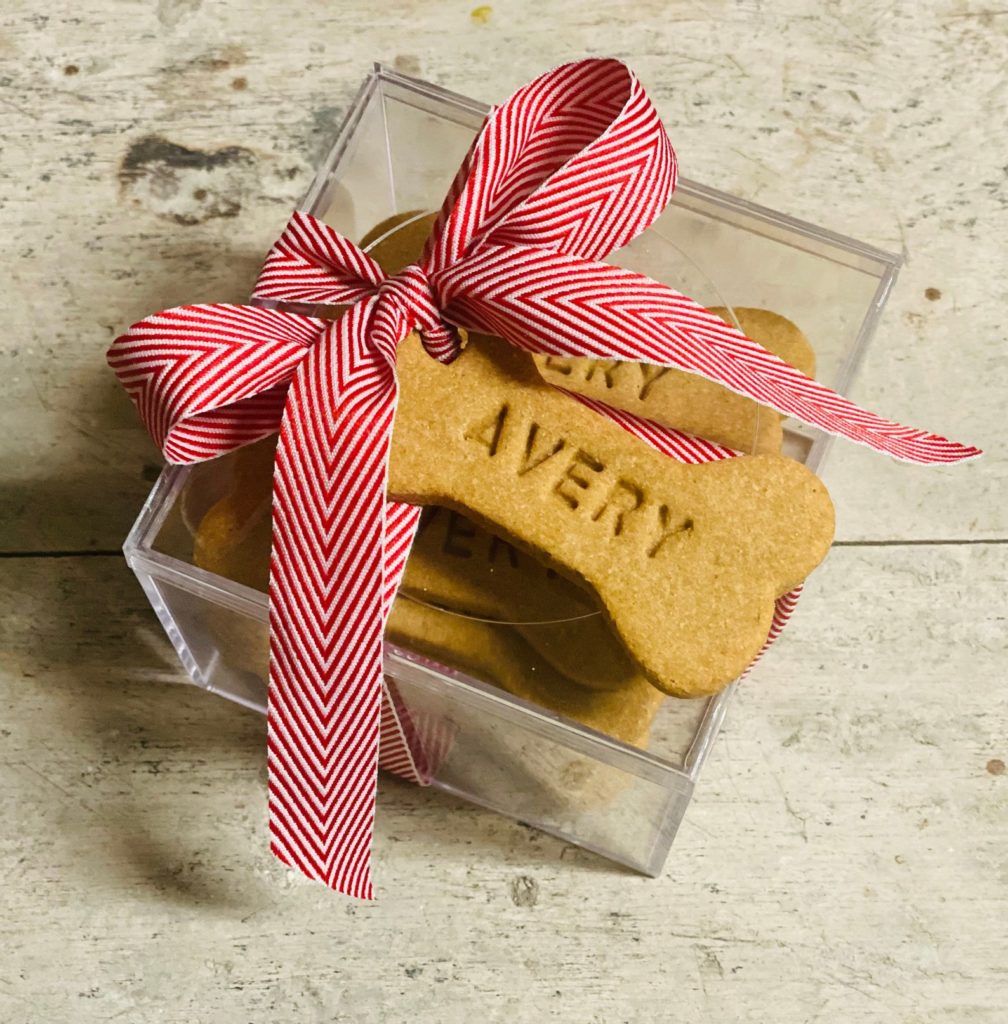 Personalized dog treats boxed with a red and white ribbon for gift giving from Good Bones Company